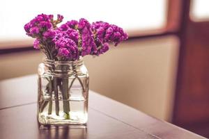 Purple flowers in a glass jar photo