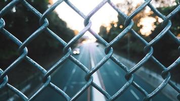 Grey chain-link fence and a road photo