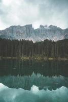 Reflection of trees and mountains in a blue lake photo