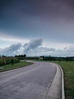 Coche pasando por una carretera durante un día nublado foto