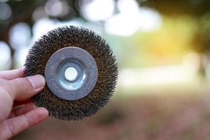 Hand holding a steel power wire brush photo