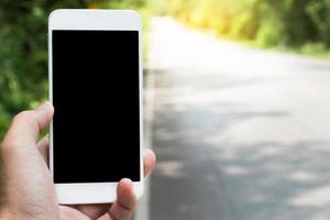 Close-up of a blank phone and a road photo