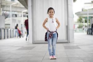 Smart little girl standing in city photo