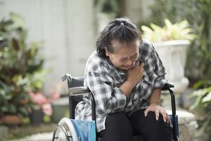 Anciana con enfermedad cardíaca sentada en silla de ruedas foto