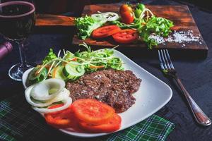 Grilled steak and red wine on the table photo