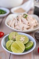 Close-up of a bowl of sliced limes on a wooden table photo