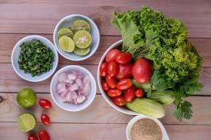 Boiled chicken pieces with vegetables and spices on a wooden table photo