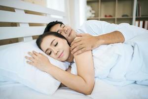 Happy couple laying together in their bed photo