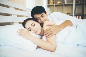 Happy couple laying together in their bed photo