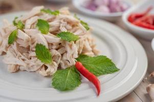 Chicken salad on a white plate with mint leaves photo