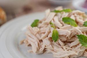 Chicken salad on a white plate with mint leaves photo