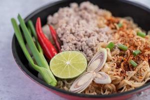 Minced pork in a frying pan with lime, chilies, and meatballs photo