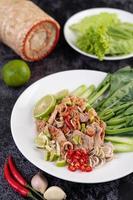 Spicy lime pork salad on a bed of greens photo