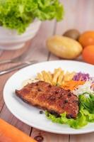 Fish steak with french fries, fruit and vegetables photo