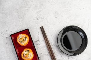 sushi plateado con salsa y palillos foto
