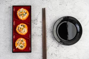 sushi plateado con salsa y palillos foto