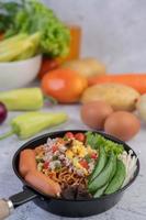 Stir-fried noodles with minced pork, edamame, tomatoes and mushrooms photo