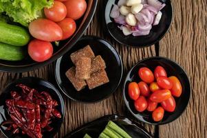 Palm sugar, red onions, dried peppers, tomatoes, cucumbers, yard long beans and lettuce photo