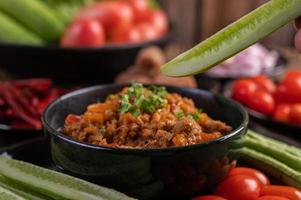 Pork with cucumbers, long beans, tomatoes and side dishes photo