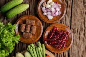 Palm sugar, red onions, dried peppers, tomatoes, cucumbers, yard long beans and lettuce photo