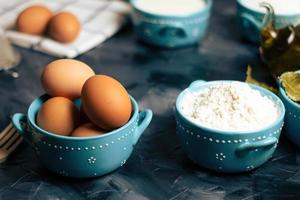 huevos y harina en cuencos foto