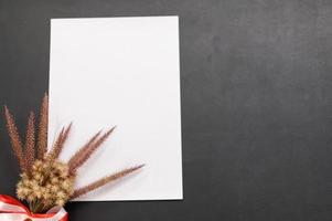 papel en blanco y flor en el escritorio foto