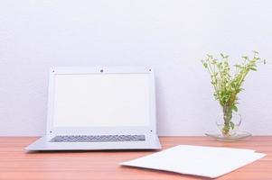 Laptop and flower on the desk photo