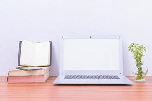 computadora portátil y libros en el escritorio foto