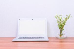 Laptop and flower on the desk photo