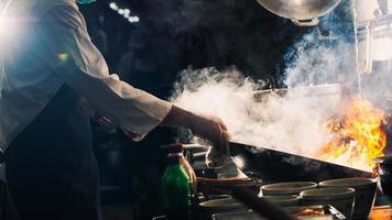 Chef salteando en wok foto