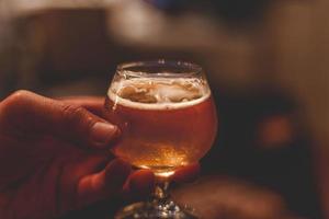 Person holding a glass of beer photo