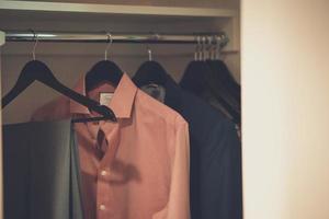 Clothes hanging in a closet photo