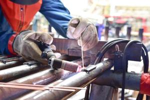 The welder is welding the plate to the pipe photo