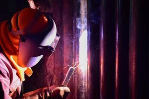 The welder is welding the pipe wall photo