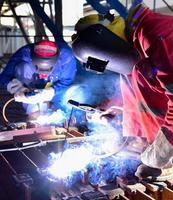 Two welders assembling the workpiece photo