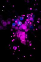 La luz púrpura del bokeh celebra en la noche, desenfoque de fondo abstracto claro. foto