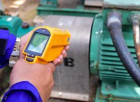 Measuring the temperature of motor with infrared thermometer photo