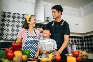 Happy family cutting vegetables together in their kitchen photo