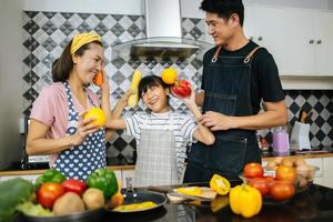 Happy family cutting vegetables together in their kitchen photo