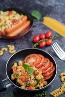 Fried macaroni and sausage in a frying pan photo