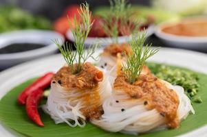 Rice noodle noodles topped with coconut milk and vegetables photo