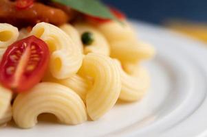 Stir-fried macaroni with tomato, chili, pepper seeds and basil photo