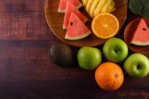 sandía de colores, piña, naranjas con aguacate y manzanas foto