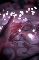 Person holding black-framed eyeglasses photo