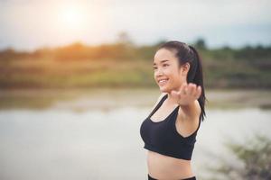 Healthy young woman warming up outdoors for training