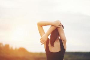 Healthy young woman warming up outdoors for training photo