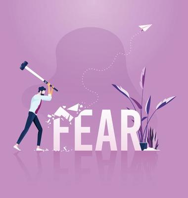 Businessman holding sledgehammer hitting fear word