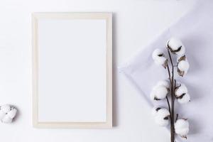 Wood photo frame with cotton flower and white fabric on white background