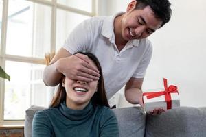 hombre sorprende a su novia con caja de regalo. foto