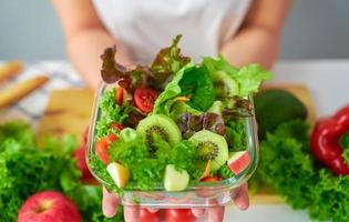 Woman hands showing salad bowl photo